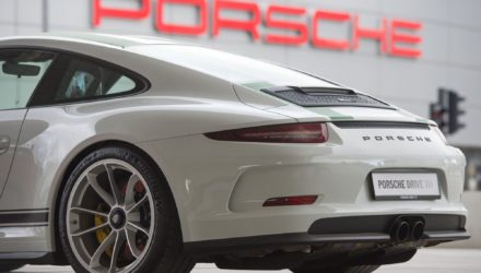 Une Porsche 911 devant le logo de la marque