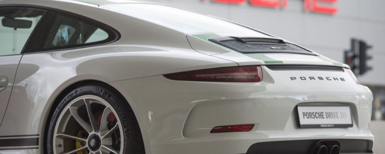 Une Porsche 911 devant le logo de la marque