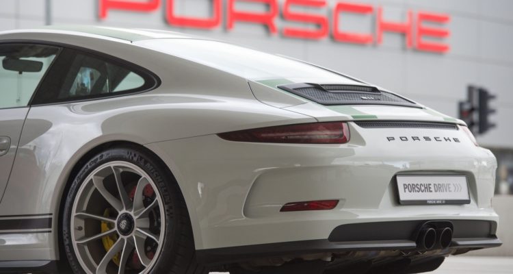 Une Porsche 911 devant le logo de la marque