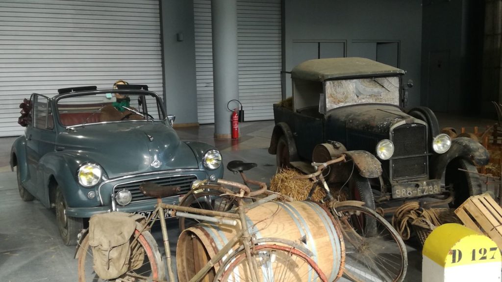 Des véhicules anciens dans un décor de ferme